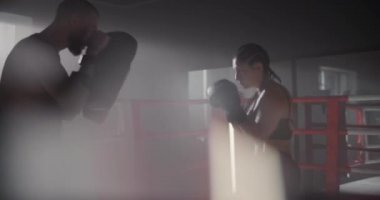 Boks Eldiveni ve Spor Giysileri Giyen Genç Kadın Sporcu Yetenekli Eğitmeniyle Boks Yapıyor. Boks ringinde çalışırken yumruklardan kaçıyorlar..