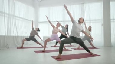 Yoga sınıfındaki beş genç kadın ve erkek, meditasyon egzersizleri. Fitness Stüdyosu ve Jimnastik sınıfında Sağlıklı Yaşam Tarzı Uzatmak ve Egzersiz Grubu