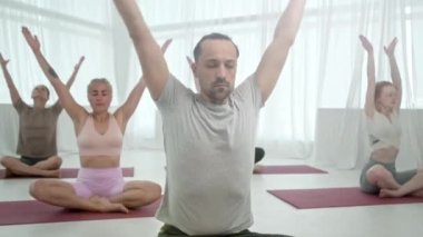 Yoga sınıfındaki beş genç kadın ve erkek, meditasyon egzersizleri. Fitness Stüdyosu ve Jimnastik sınıfında Sağlıklı Yaşam Tarzı Uzatmak ve Egzersiz Grubu