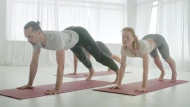 Yoga sınıfındaki beş genç kadın ve erkek, meditasyon egzersizleri. Fitness Stüdyosu ve Jimnastik sınıfında Sağlıklı Yaşam Tarzı Uzatmak ve Egzersiz Grubu