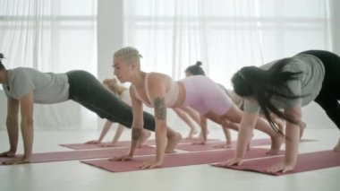 Yoga sınıfındaki beş genç kadın ve erkek, meditasyon egzersizleri. Fitness Stüdyosu ve Jimnastik sınıfında Sağlıklı Yaşam Tarzı Uzatmak ve Egzersiz Grubu