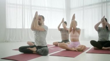 Genç Sportif İnsanlar Spor Salonunda Namaste Pozu Veren Eğitmenle Yoga Dersi Çalışıyor. Rahatlatıcı vücut. Sağlık, Meditasyon ve Sağlık Konsepti.