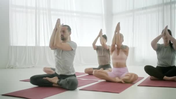 Mladí sportovci Atraktivní lidé Cvičení jógy Lekce s instruktorem Namaste Pose v tělocvičně Studio. Uvolňující tělo. Zdraví, meditace a wellness koncepce. — Stock video