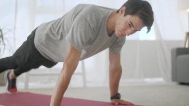 Kas Adam Spor Yapıyor ve Matta Üzerinde Çalışıyor. Bir Tablet Uygulaması kullanarak Plank Egzersizi Yapan Bir Çok Stamina Atleti, Bir Kronometrede Zamanlama.