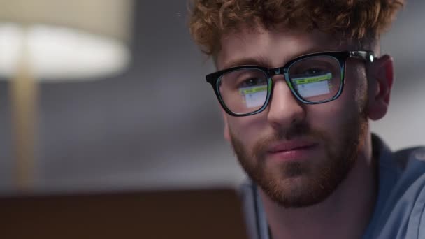 Gece Çalışan Adamın Portresi Monitöre Bakıyor, Gözlüklerdeki Yansımalar. Gözlüklü Erkek Gözü Gece Dizüstü Bilgisayarın Önünde Kaydırıyor. İnternet Sörfü — Stok video