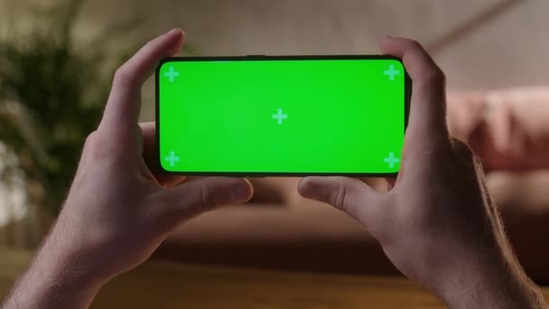 Cámara de mano: Vista trasera del hombre en el teléfono con pantalla verde para copiar espacio. Chromakey se burla de los marcadores de seguimiento. Pulse para hacer clic en Centro de pantalla — Vídeos de Stock