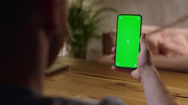 El kamerası: Evde Krom Anahtar Tutan Genç Adam Yeşil Ekran Telefonu Dokunmadan ve Çalkalamadan İzleme İçeriği. İnternet taraması, İçerik İzleme, Videolar