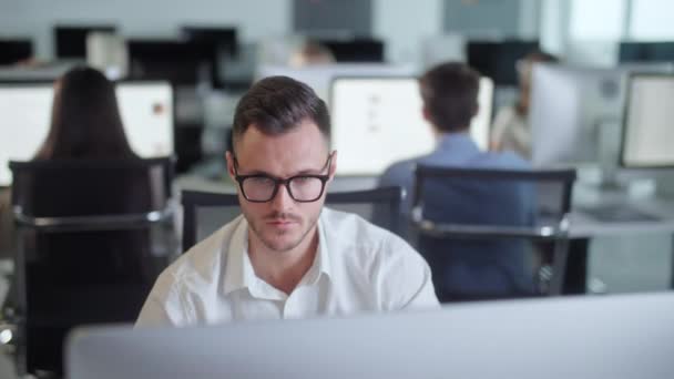 Serious Young Man Travailler sur DecXoComputer tout en travaillant dans Big Open Space Office. Portrait d'un homme d'affaires positif regardant l'écran d'ordinateur à l'intérieur. — Video