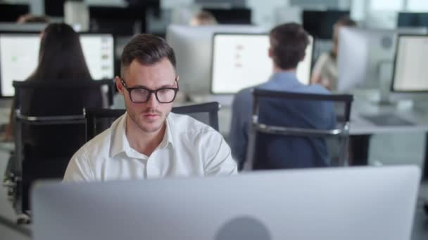 Retrato de Joven Empresario en Oficina de Espacio Abierto Trabajando en Decjalá Computer. Mecanografía profesional masculina en el teclado de PC. Retrato del hombre de negocios positivo mirando la pantalla de la computadora — Vídeos de Stock