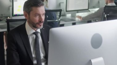 Açık Uzay Ofisinde Orta yaşlı bir adamın portresi güverte bilgisayarında çalışıyor. Ofis İş Yerindeki PC Klavyesinde Erkek Profesyonel Daktilo.
