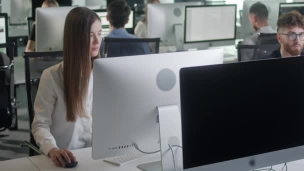 Attraente giovane donna che lavora sul computer Decktop mentre lavora in Big Open Space Office. Ritratto di donna d'affari positiva che guarda lo schermo del computer all'interno. — Video Stock