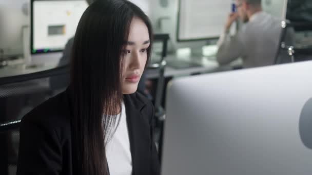 Vonzó ázsiai nő dolgozik Decktop Computer, miközben dolgozik a Big Open Space Office. Portré a pozitív üzleti nő néz számítógép képernyő beltéri. — Stock videók