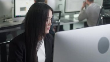 Büyük Açık Uzay Ofisi 'nde çalışırken güverte bilgisayarında çalışan çekici genç kadın. İçerideki Bilgisayar Ekranına Bakan Pozitif İş Kadını Portresi.