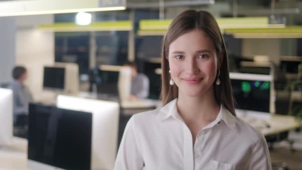 Front view of beautiful young Woman professional Wearing White Shirt. Portrait of young female office manager looking to camera and having good mood. Blurred office background. — Stock Video