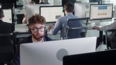 Bir çağrı merkezinde bilgisayar üzerinde çalışırken Kulaklıkla konuşan Teknik Müşteri Destek Uzmanının Portre Adamı 'nı Kapat. Çeşitli işçi grupları yardım hattında görüşüyor..