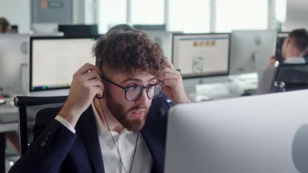Närbild Porträtt av en teknisk kundsupport Specialist Prata på ett headset medan du arbetar på en dator i callcenter och hjälpsam kundservice 24-7. — Stockvideo