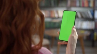 Dokunmadan Yeşil Ekran. İçişleri Bakanlığı 'nda ya da Kütüphane İzleme İçeriğinde Krom Anahtar Yeşil Ekran Telefonu Tutan Kadın Görünümü. İnternet taraması, İçerik İzleme, Videolar, Bloglar.