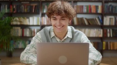 Laptop Arama Bilgileri İnternet Kursu Çalışması Kullanan Çekici Öğrenci Sınav Araştırması yapan Laptop Monitörüne bakarak Uygulamada Öğrenme Kütüphane Masasında Oturup Gülümseme