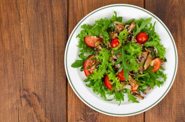 Tahta masada roka yapraklı diyet salatası, domates ve kızarmış mantar. Stüdyo Fotoğrafı.