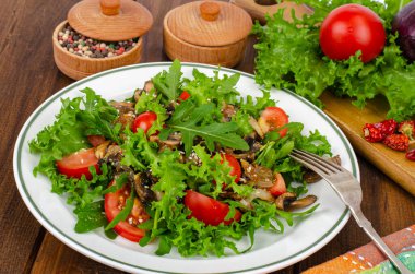 Tahta masada roka yapraklı diyet salatası, domates ve kızarmış mantar. Stüdyo Fotoğrafı.