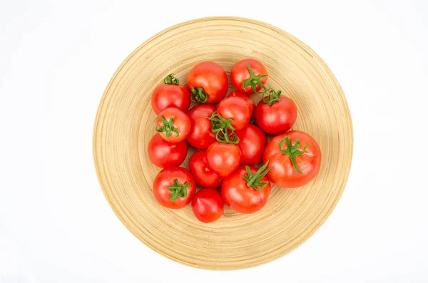 large wooden bamboo dish with ripe tomatoes. Studio Photo