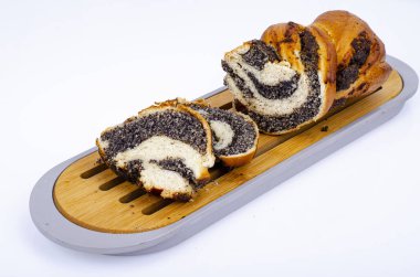 Tahta tepside haşhaş tohumlu dilimlenmiş ekmek. Ev yapımı pişirme. Fotoğraf.