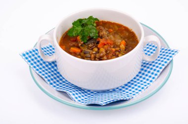 Beyaz tabakta mercimek ve sebze çorbası. Fotoğraf.