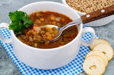 Beyaz tabakta mercimek ve sebze çorbası. Fotoğraf.