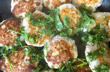 Pirzola, taze kesilmiş otlarla serpilmiş, eski bir tavada. Fotoğraf.