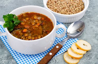 Beyaz tabakta mercimek ve sebze çorbası. Fotoğraf.