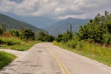 Dağlarda güneşli bir yaz gününde Pozar köyü yakınlarındaki kırsal yol (Yunanistan, Orta Makedonya)