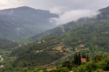 Manzara. Dağlar ve orman bir yaz günü sislerin içinde boğuluyor, bulutlu bir gün (Mora, Yunanistan)