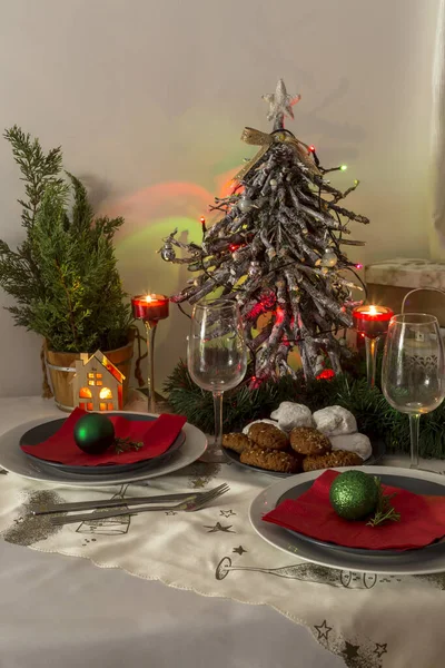 クリスマスと新年のデザイン テーブルの近くには クリスマスの装飾プレート ナイフ フォーク ガラスのようなギリシャのお菓子 Melomacarona Kourabies がたくさんあります — ストック写真