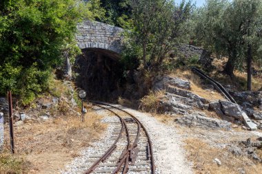 Güneşli bir yaz gününde dağlardaki (Yunanistan, Pelion) turist, eski, demiryolu rayları