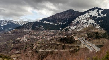 Kışın, bulutlu, sisli bir günde, büyük, karlı dağ ve yolların (Epirus bölgesi, Yunanistan) manzarası