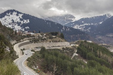 Kışın, bulutlu, sisli bir günde, büyük, karlı dağ ve yolların (Epirus bölgesi, Yunanistan) manzarası