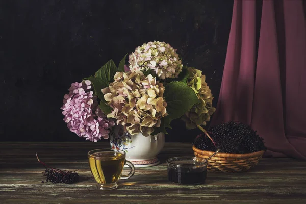 Stilleven Met Zachte Hortensia Een Kopje Thee Vlierbessenjam Een Mand — Stockfoto