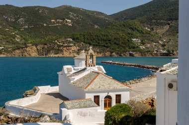 The panoramic view of the white, ancient church (island Skopelos, Northern Sporades, Greece), the sea and the mountains on a summer day