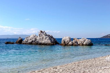 Güneşli bir yaz gününde, temiz, güzel, kumlu sahil, dağlar ve deniz manzarası.)