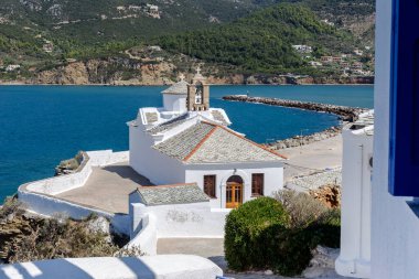 The panoramic view of the white, ancient church (island Skopelos, Northern Sporades, Greece), the sea and the mountains on a summer day