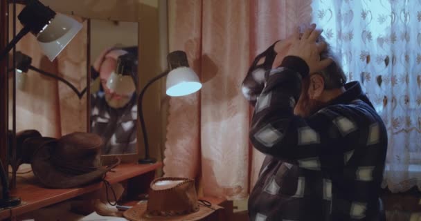 Fešák starší muž opravuje vlasy, nasazuje klobouk a kokety na zrcadlo — Stock video