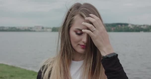 Encantadora chica con cara alegre corrige su cabello en la mañana en la playa — Vídeos de Stock