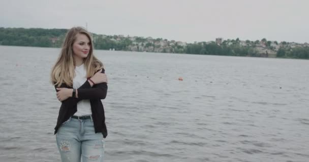 Glückliches Mädchen, das sich von der Kälte umarmt und bei Wind freudig in den Himmel blickt — Stockvideo