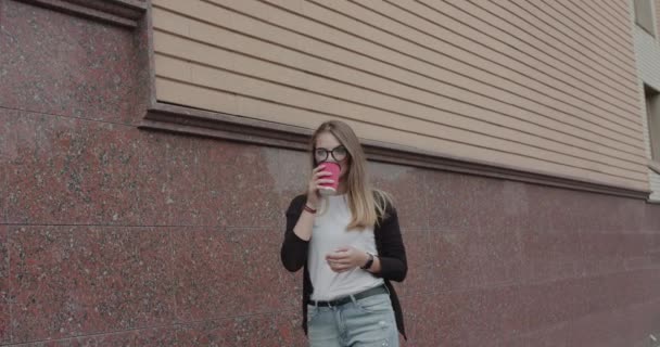喜びの少女は、飲み物のカップを飲むスマートブレスレットと笑顔で時計 — ストック動画