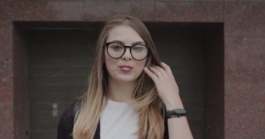 Gözlüklü hippi sakız çiğniyor ve patlatarak eğleniyor.