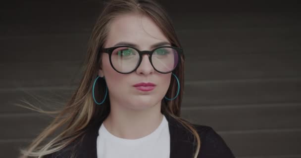 Adolescente elegante em óculos infla bolha de chiclete e se diverte — Vídeo de Stock