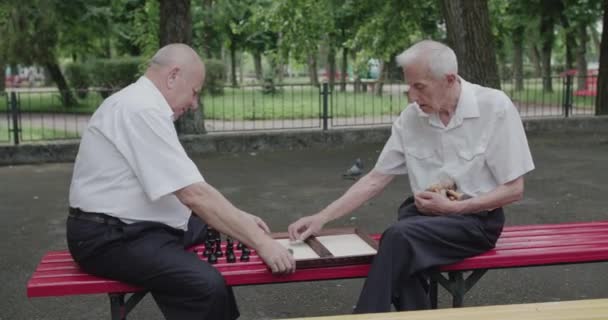 Twee senioren die het schaakbord voorbereiden voor een wedstrijd op de bank — Stockvideo