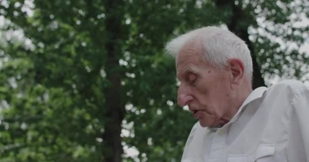 Yazın boş zamanlarında biriyle konuşan yaşlı bir adamın profil görüntüsü — Stok video