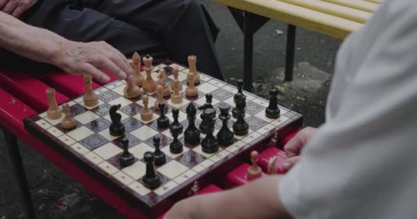 Vista de amigos de la tercera edad jugando al ajedrez. El hombre se mueve y se regocija — Vídeo de stock