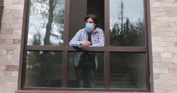 Mann schaut aus dem Fenster, wirft Maske raus, atmet erleichtert frische Luft, lächelt — Stockvideo